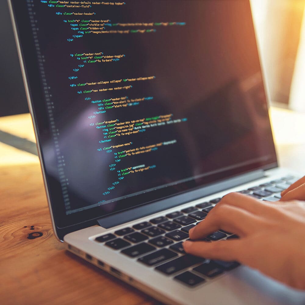 Writing website code on a laptop
